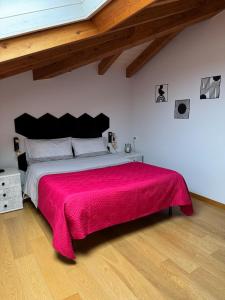 a bedroom with a large bed with a red blanket at Casa vacanza Valentina in Vogogna