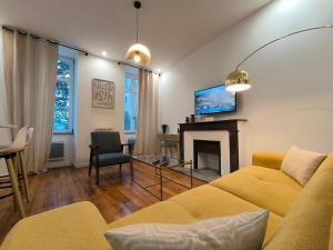 ein Wohnzimmer mit einem gelben Sofa und einem Kamin in der Unterkunft Henri IV in Pau