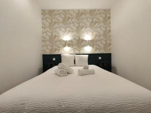 ein Schlafzimmer mit einem Bett mit zwei Handtüchern darauf in der Unterkunft Henri IV in Pau