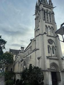 eine Kirche mit einem Turm mit einer Uhr drauf in der Unterkunft Henri IV in Pau