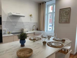 eine Küche mit einem Tisch und Weingläsern darauf in der Unterkunft Henri IV in Pau + 30 Fotos