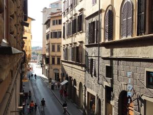 un callejón con gente caminando por una calle entre edificios en Berardi Palace Apartments, en Florencia