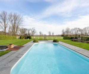 a swimming pool in the yard of a house at Villa Blauw in De Panne
