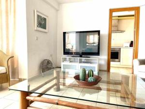 a living room with a tv and a glass table at Apartamento Sea View By Solymar Holiday in Torre del Mar