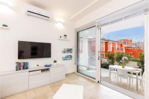 a living room with a large sliding glass door and a television at Navarra Beach House in Santa Maria Navarrese