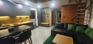 a living room with a couch and a kitchen at OFF Chata na Oślaku, Jacuzzi & Sauna in Jaworzna