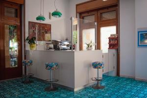 una cocina con 2 taburetes y una barra en Hotel Mediterraneo, en Guardia Piemontese Terme