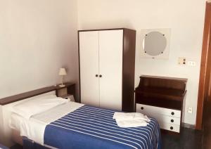 Un dormitorio con una cama, una cómoda y un espejo. en Hotel Mediterraneo, en Guardia Piemontese Terme