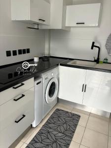 a kitchen with a washing machine in a kitchen at Duplex cosy au cœur de Sinnamary, fleuve à pied- Samélé House in Sinnamary +10 photos
