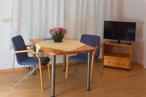 a dining room table with chairs and a television at Gästehaus Schiff in Meersburg
