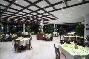 un ristorante con tavoli e sedie bianchi e cercatore di tavoli di Therma Vitae - Профилакториум Огняново a Ognyanovo