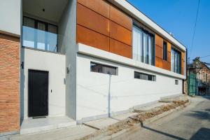 a white building with a black door on a street at Villa in Avlabari in Tbilisi City