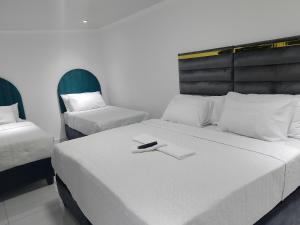 a bedroom with a bed with a remote control on it at Duminy Guest Lodge in Bellville