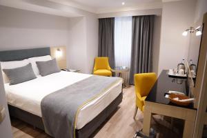 A bed or beds in a room at Amethyst Hotel