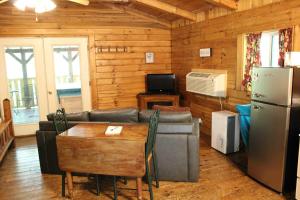 a living room with a couch and a table and a refrigerator at Wren's Nest in Logan +15 photos
