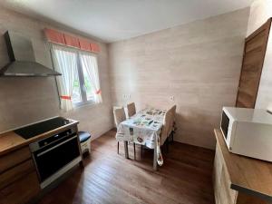 a small kitchen with a table and a small kitchen with a table and chairs at Apartamento El Pedregal in Castro-Urdiales