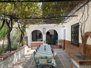 a patio with a long table in a building at Lovely 10-Bed Villa with Private Pool & Garden in Cacin