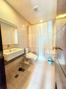 a bathroom with a toilet and a sink and a mirror at 2 Bedroom unit near airport in Lapu Lapu City