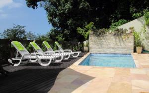 a group of lounge chairs next to a swimming pool at Casa Verde in Rio de Janeiro