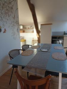une table bleue avec des chaises dans la cuisine dans l'établissement Gîte Le Nid aux Papillons, à Palinges 19 autres photos