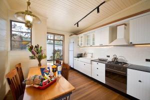 a kitchen with a wooden table and a kitchen with white cabinets at Seven Sisters Escarpment Views in Medlow Bath