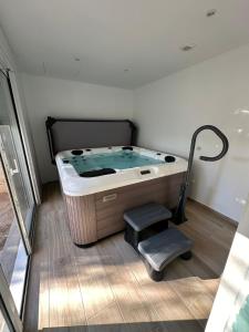 un jacuzzi dans une pièce avec deux marches dans l'établissement Oasis de Thau, à Balaruc-les-Bains
