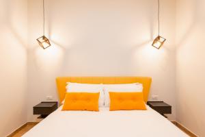 een slaapkamer met een oranje bed en 2 oranje kussens bij Ventuno Dei Luxury Suites San Giovanni in Rome