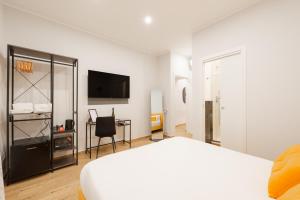 een slaapkamer met een bed, een bureau en een televisie bij Ventuno Dei Luxury Suites San Giovanni in Rome +25 foto's