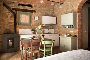 a kitchen and dining room with a table and chairs at Il Borghetto - La Bottega di Adele Loft in Castelnuovo dellʼAbate