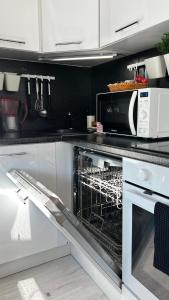 a kitchen with an open oven with a microwave at City Center Apartment in Narva
