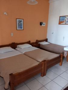 a room with three beds in a room at Antikristo Rooms in Karteros