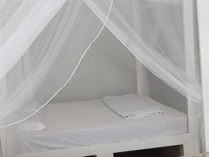 a white room with a bed with white curtains at C-Born in Hikkaduwa +29 photos