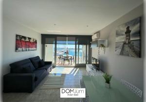 een woonkamer met een bank en uitzicht op de oceaan bij DOMuum Holidays - POSIT MAR in Cambrils