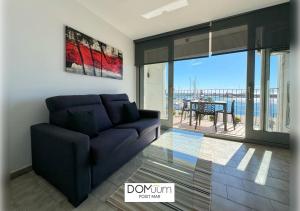 een woonkamer met een bank en uitzicht op de oceaan bij DOMuum Holidays - POSIT MAR in Cambrils