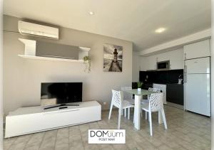 een woonkamer met een tafel en een keuken bij DOMuum Holidays - POSIT MAR in Cambrils