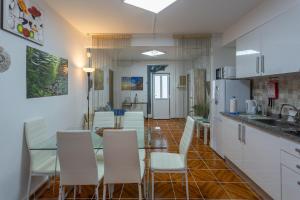 コスタ・ダ・カパリカにあるBeGuest Caparica Sun & Beachのテーブルと椅子のあるキッチンとダイニングルーム