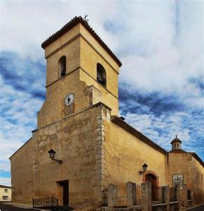 a building with a clock tower on top of it at Hotel Apartamento Via Caprasia Habitaciones&Apartamentos in Villargordo del Cabriel