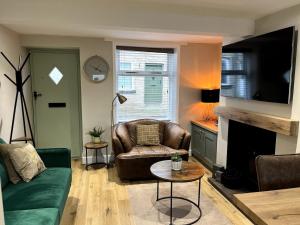 a living room with a couch and a chair at Charming Cosy Cottage in Bollington Village in Bollington
