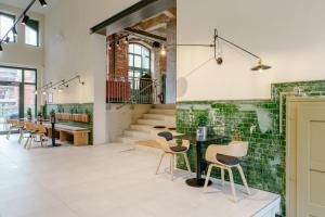 a room with a table and chairs and a staircase at fabrik studio apartments in Chemnitz