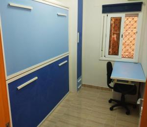 an office with a blue door and a desk at Apartament inclusiu Coma-ruga in Comarruga +2 photos