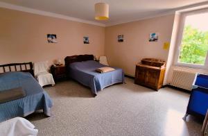 a bedroom with two beds and a window at La Maison du Soleil in Saint-Gaudéric +29 photos