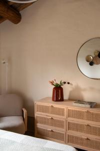 a bedroom with a dresser and a chair and a mirror at Il Borghetto - Oliviera Townhouse in San Giovanni dʼAsso