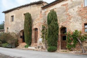 an old stone building with two trees in front of it at Il Borghetto - Oliviera Townhouse in San Giovanni dʼAsso