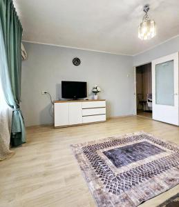 ein leeres Wohnzimmer mit einem TV und einem Teppich in der Unterkunft Уютная квартира на Тверская 5, пр Правды, клиника Рохманова in Dnipro