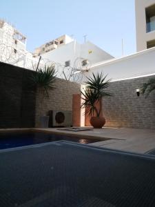 a swimming pool with two plants in a building at Résidence Bambou in Dakar