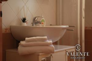 a bathroom with a sink and a pile of towels at Cozy apartment in Follonica in Follonica