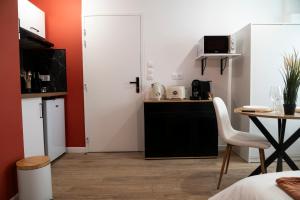 a small kitchen with a table and a white door at Le Terracotta - Centre ville in Marmande