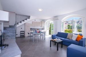 a living room with a blue couch and a kitchen at spiaggia uno pool side apartment in Bellagio +31 photos