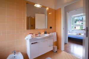 a bathroom with a sink and a mirror and a toilet at spiaggia uno pool side apartment in Bellagio +8 photos