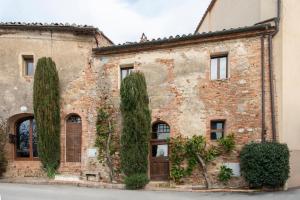 an old brick building with trees in front of it at Il Borghetto - Oliviera loft in San Giovanni dʼAsso